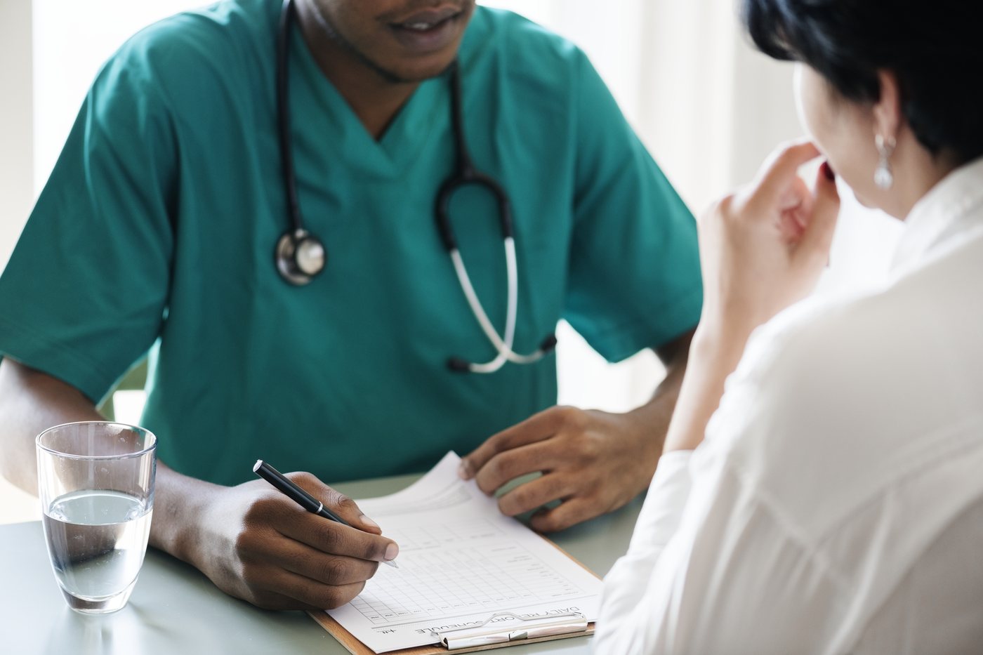 Care plan review: a clinician going through a written plan with a patient at a desk