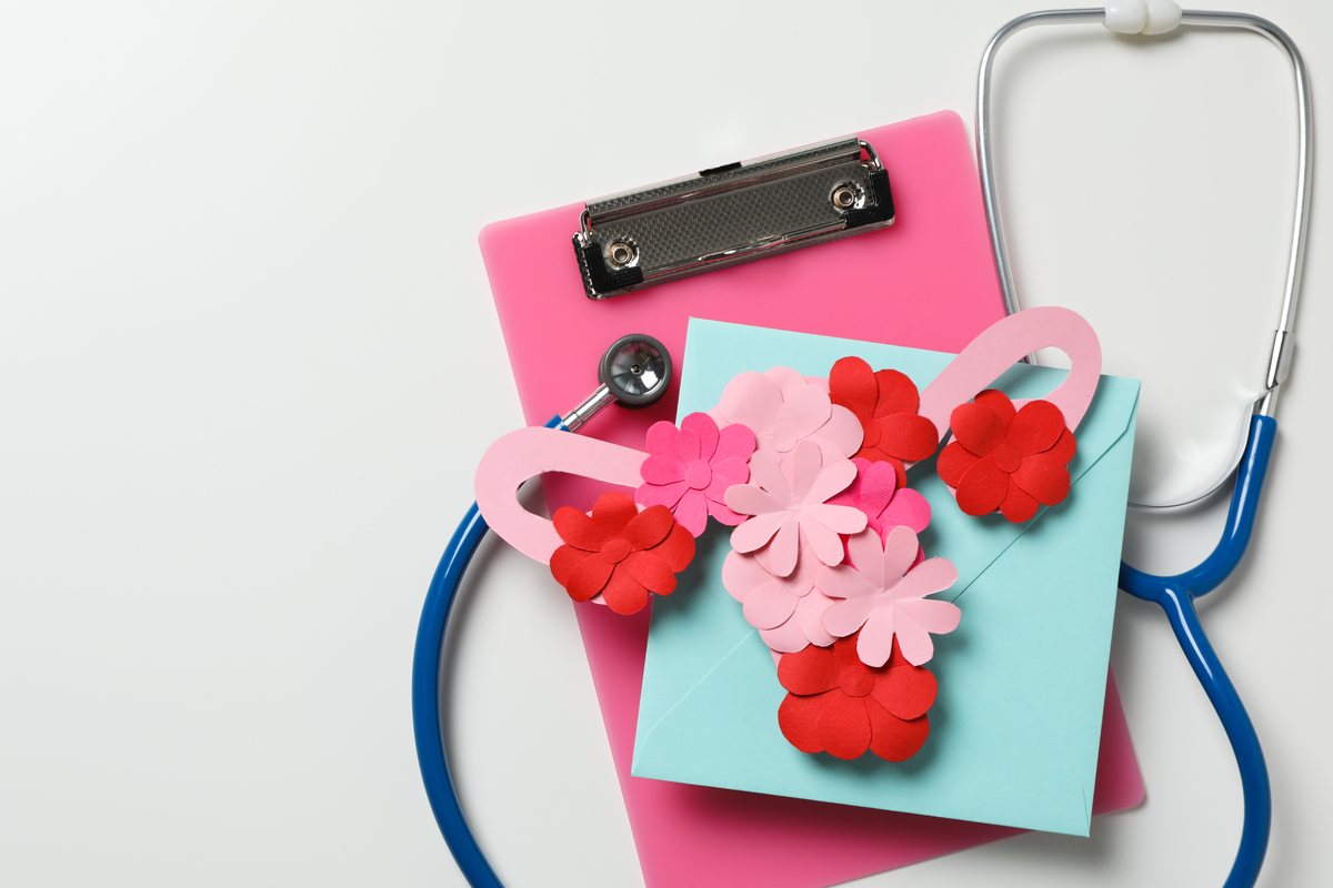 Cervical screening: a stethoscope and clipboard beside a paper illustration of a uterus