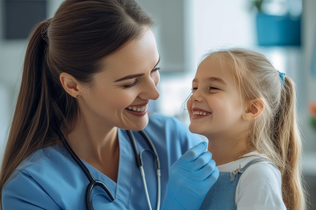 Childhood immunisation: a nurse and a young girl smiling at each other during a health check