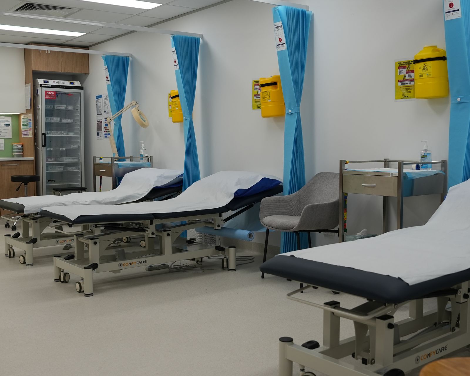 The treatment room at Gosford Doctors, West Gosford, with three curtained beds and a vaccine fridge