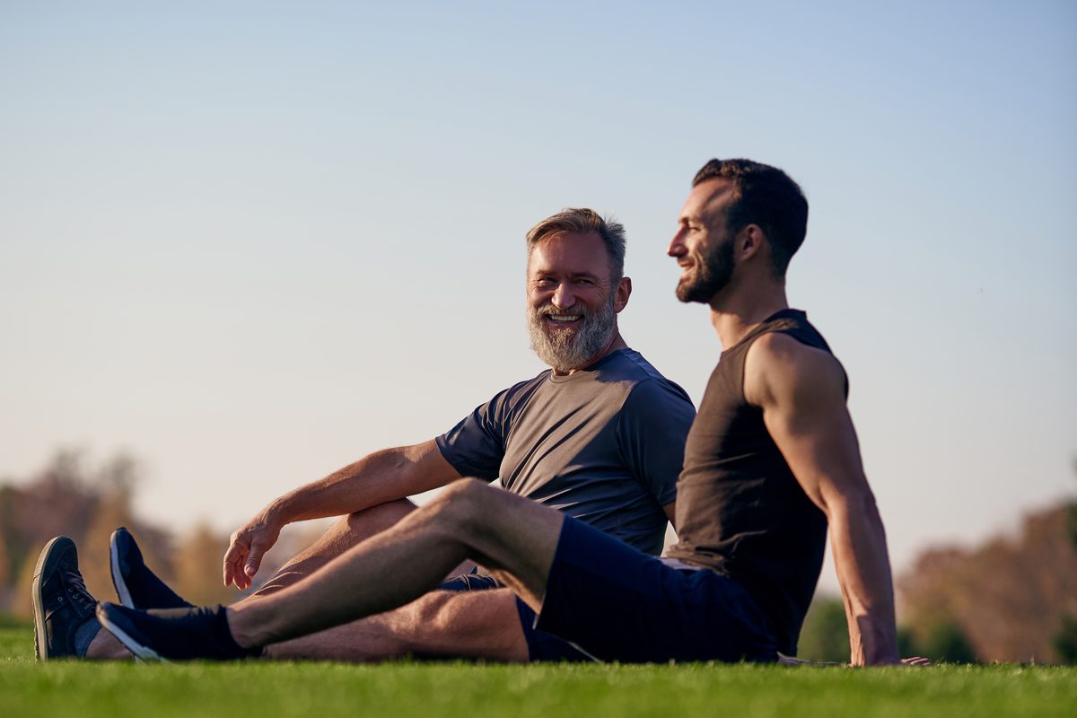 Men&rsquo;s health checks: two men resting on the grass after exercise outdoors