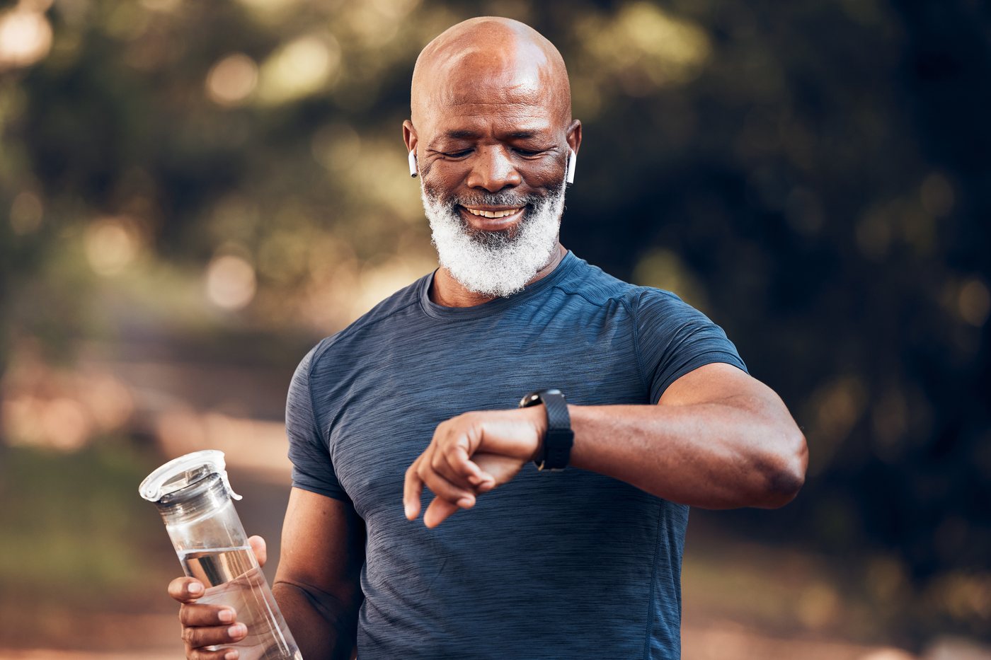 Men's health checks: a man in his sixties checking a fitness watch during a walk