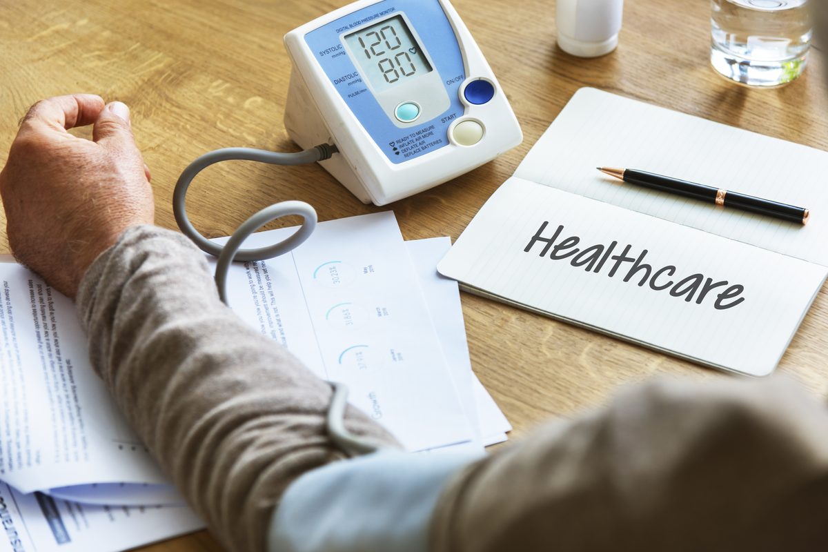 Preventive health check: a blood pressure monitor, test results and a notepad on a desk