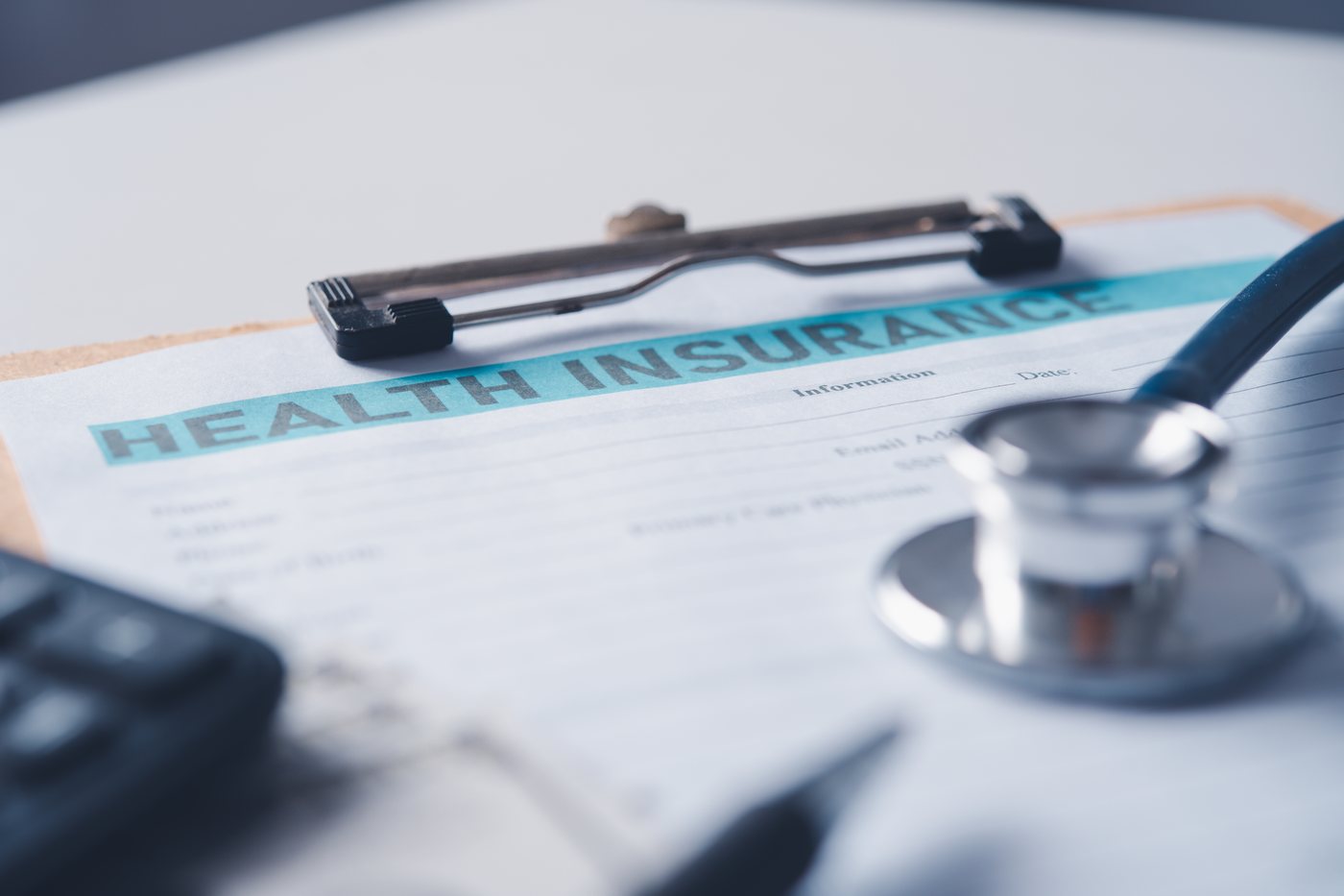 Private medical assessment: an insurance and employment health form on a clipboard beside a stethoscope