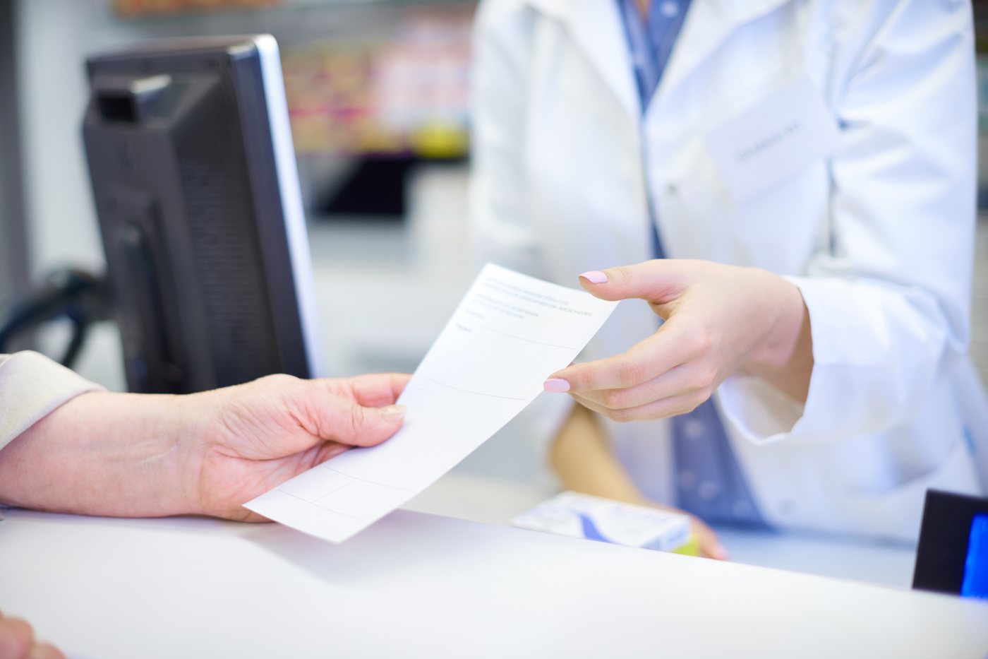 Repeat prescriptions: a prescription being handed across a pharmacy counter