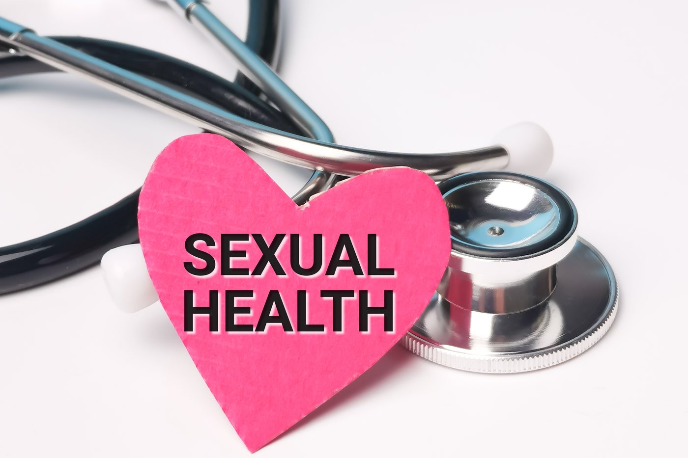 Sexual health: a pink heart card reading sexual health beside a stethoscope