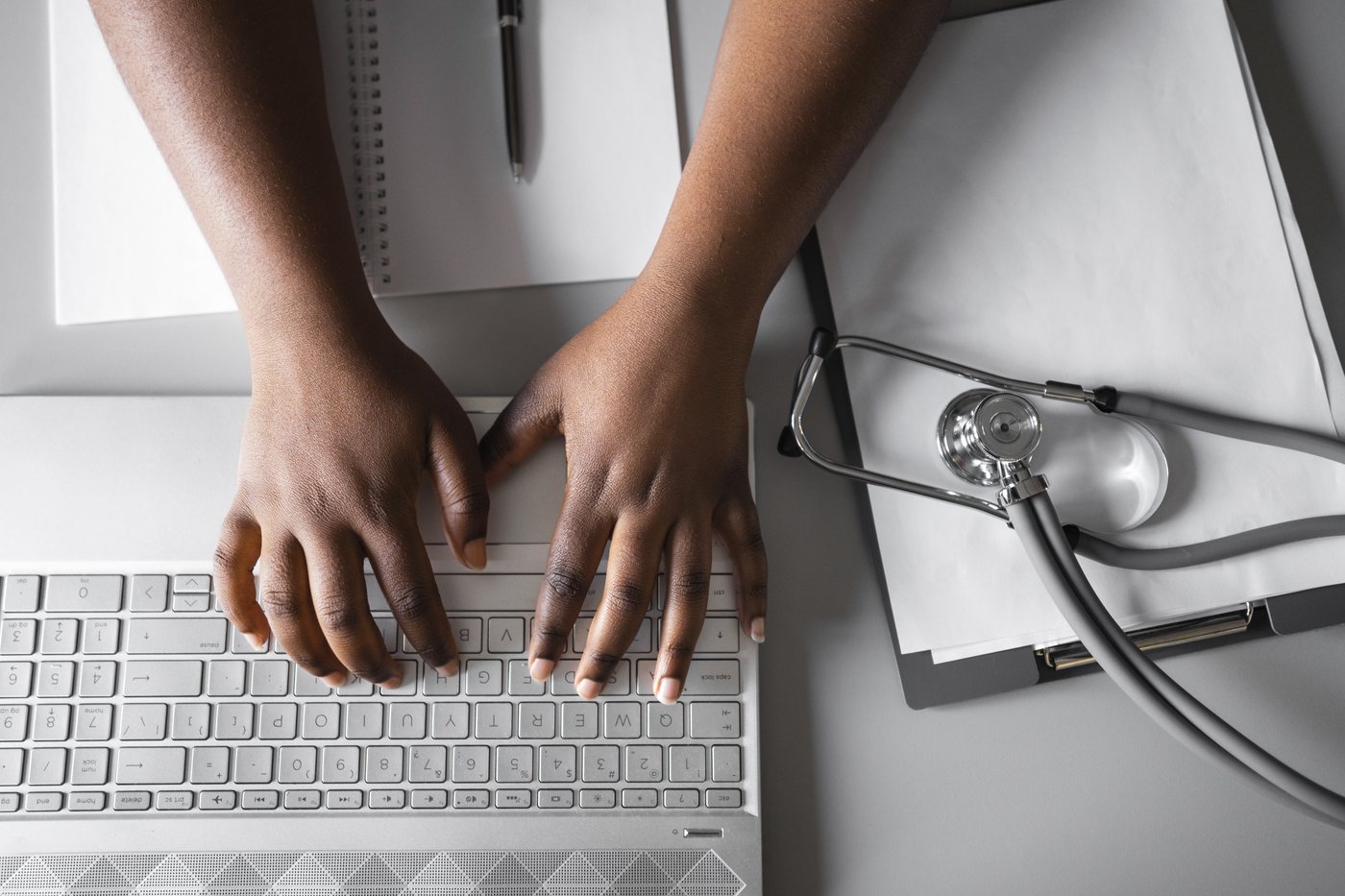Specialist referrals: a GP writing a referral letter at a desk with a stethoscope and notes