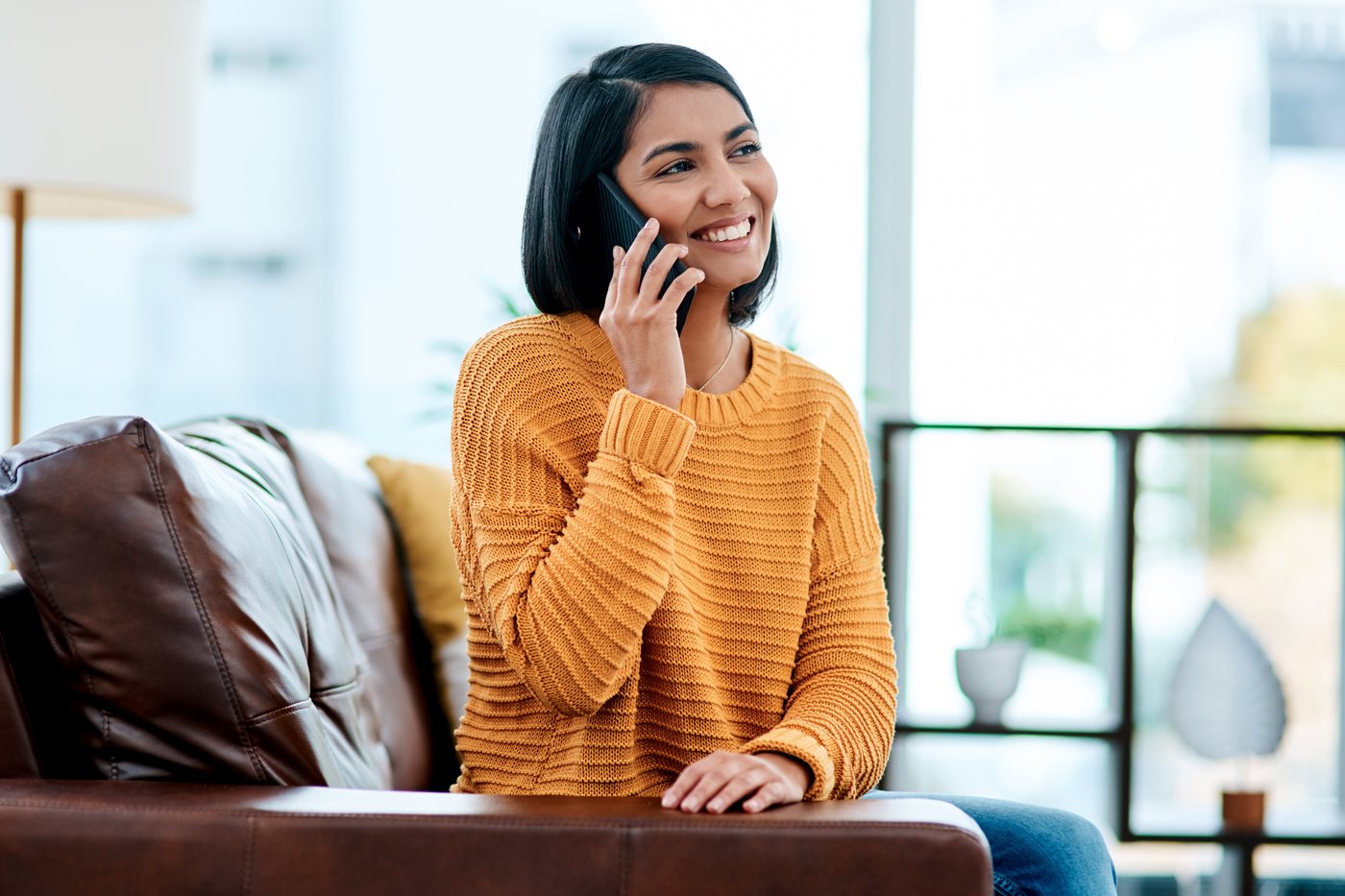 Telehealth: a woman taking a phone call at home on the couch